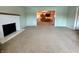 Cozy living room with a white fireplace, carpet, and an open view into the kitchen area at 5850 Paradise Ln, Martinsville, IN 46151