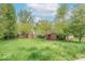 Spacious backyard featuring lush greenery and a charming red storage shed at 613 Barrett St, Danville, IN 46122