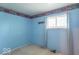 Unfurnished bedroom painted blue with a window and outdated decor at 613 Barrett St, Danville, IN 46122