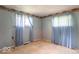 Empty bedroom featuring two windows with curtains, wallpaper border, and bare floors at 613 Barrett St, Danville, IN 46122