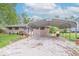 A charming single-story home featuring a carport and a gravel driveway, surrounded by a well-maintained lawn at 613 Barrett St, Danville, IN 46122
