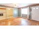 A spacious living room with hardwood floors, a large window, and a view of the fireplace room at 613 Barrett St, Danville, IN 46122
