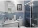 Cozy bathroom featuring a blue tiled shower/tub combo, vanity, and toilet at 6204 S Madison Ave, Indianapolis, IN 46227