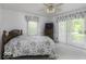 Bright bedroom featuring a ceiling fan, dresser with television, and sliding glass door to the outside at 6204 S Madison Ave, Indianapolis, IN 46227