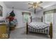 Neutral bedroom with a ceiling fan, multiple windows, and light-colored carpet at 6204 S Madison Ave, Indianapolis, IN 46227