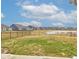 Large backyard with grass and a pond view surrounded by a fence in a quiet community at 6615 Aberdeen Dr, McCordsville, IN 46055