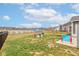 Large grassy backyard with a black metal fence, pond, blue sky and play equipment at 6615 Aberdeen Dr, McCordsville, IN 46055
