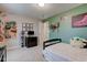 A carpeted bedroom with light green walls, a bed, and a display of toy guns on the wall at 6615 Aberdeen Dr, McCordsville, IN 46055