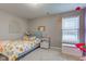 A carpeted bedroom with a floral bedspread, a window overlooking a lake, and neutral color scheme at 6615 Aberdeen Dr, McCordsville, IN 46055