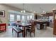 Bright dining area with dark wood table, modern light fixture, and open concept layout to the kitchen at 6615 Aberdeen Dr, McCordsville, IN 46055