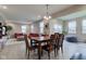 Open floor plan dining area with wood floors, natural light, and adjacent living room at 6615 Aberdeen Dr, McCordsville, IN 46055