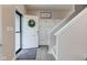 Bright entryway with a hall tree coat rack, wood floors, and decorative wreath on front door at 6615 Aberdeen Dr, McCordsville, IN 46055