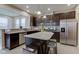 Modern kitchen with stainless appliances, granite countertops, island, and dark cabinets at 6615 Aberdeen Dr, McCordsville, IN 46055