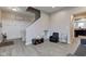 Open-concept living room with wood flooring, neutral paint, coat rack, and staircase at 6615 Aberdeen Dr, McCordsville, IN 46055