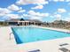 Beautiful community pool with plenty of lounge chairs available for residents on a sunny day with blue skies and fluffy white clouds at 6615 Aberdeen Dr, McCordsville, IN 46055