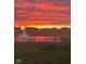 Beautiful sunset view overlooking a fountain in a pond, observed from a grassy yard with chairs at 6615 Aberdeen Dr, McCordsville, IN 46055