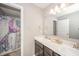 Bathroom with a double vanity, shower with mermaid shower curtain, and neutral decor at 6699 Dunkirk Dr, McCordsville, IN 46055