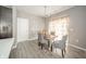 Dining room with a table, upholstered chairs, decorative curtains, and stylish light fixture at 6699 Dunkirk Dr, McCordsville, IN 46055