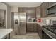 A well-equipped kitchen with stainless steel refrigerator, gas range, and subway tile backsplash at 6699 Dunkirk Dr, McCordsville, IN 46055