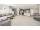 Open-concept living room with gray furniture and carpet, seamlessly connecting to the kitchen and dining area at 6699 Dunkirk Dr, McCordsville, IN 46055