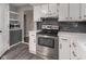 Updated kitchen with stainless steel appliances, white cabinets, and modern backsplash at 7089 W Us Highway 36, Danville, IN 46122