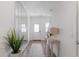 Bright entryway featuring a modern mirror, light wood flooring, and a view of the front door at 737 Oxford Ln, Danville, IN 46122