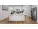 Modern kitchen featuring white cabinets, stainless steel appliances, a large island, and beautiful hardwood floors at 737 Oxford Ln, Danville, IN 46122