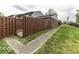 A grassy backyard featuring a wooden fence and concrete walkway at 741 Southfield Ct, Indianapolis, IN 46227
