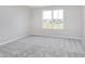 This bright, carpeted bedroom has a large window with neighborhood views at 8445 Morgan Ln, Zionsville, IN 46077