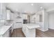 Spacious kitchen featuring stainless steel appliances, an island, white cabinets, and modern lighting at 8445 Morgan Ln, Zionsville, IN 46077