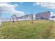 Large, fenced backyard with a lush green lawn, swing set, and mature trees providing shade at 856 Parker Ln, Westfield, IN 46074