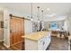 Kitchen island with barstool seating, granite counters, and modern pendant lighting adjacent to a wooden barn door at 856 Parker Ln, Westfield, IN 46074