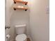 Toilet room featuring a white toilet and two rustic shelves with toilet paper storage at 983 Geronimo Dr, Greenfield, IN 46140