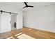 A bedroom with hardwood floors, a ceiling fan, and a barn door to bathroom at 1020 Calvary St, Indianapolis, IN 46203