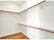 The walk-in closet features hardwood floors, white walls, shelves and wood rails for storage at 1020 Calvary St, Indianapolis, IN 46203