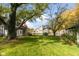 Expansive backyard with mature trees, a well-maintained lawn, and partial fencing at 117 N Leland St, Fortville, IN 46040