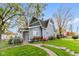 Charming two-story home featuring mature trees, a well-manicured lawn and garden, and a walkway at 117 N Leland St, Fortville, IN 46040