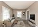 Inviting living room features a comfortable sofa, entertainment center and large windows with natural light at 117 N Leland St, Fortville, IN 46040