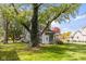Grey home with a mature tree in the front yard, partial fencing, and lush green grass at 117 N Leland St, Fortville, IN 46040