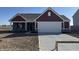 A charming home with a two-car garage, red siding, and a well-manicured lawn, ready for new owners at 1195 Andromeda Dr, Franklin, IN 46131