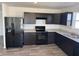 The kitchen features sleek black cabinets, modern appliances, and durable flooring at 1195 Andromeda Dr, Franklin, IN 46131