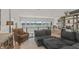 Living room with sectional sofa, leopard print chair, shelving, and large windows offering a scenic lake view at 12561 Marina View Dr, Indianapolis, IN 46256