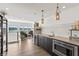 Chic wet bar adjacent to living space with lake view, wine cooler, stainless steel microwave, and pendant lights at 12561 Marina View Dr, Indianapolis, IN 46256
