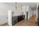 Stylish wet bar with dark cabinetry, wine cooler, stainless steel microwave, and pendant lighting near stairway at 12561 Marina View Dr, Indianapolis, IN 46256