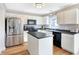 Modern kitchen featuring stainless steel appliances, white cabinetry, an island, and hardwood floors at 12635 Braddock Ln, Noblesville, IN 46060