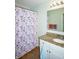 Light-filled bathroom features a granite countertop, white cabinets, and a floral shower curtain at 13509 Dunes Dr, Carmel, IN 46032