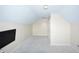 Bright, carpeted bonus room featuring sloped ceilings and a mounted TV for flexible living space at 13509 Dunes Dr, Carmel, IN 46032