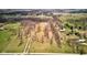 Aerial view of a large grassy property dotted with mature trees and showcasing a scenic pond at 15123 E 196Th St, Noblesville, IN 46060