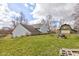 Backyard view of a home with a chimney, barn-style garage, and a fire pit, blending rustic charm and functionality at 15123 E 196Th St, Noblesville, IN 46060