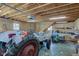 Interior of a large barn with unfinished ceiling, stairs, and a tractor at 15123 E 196Th St, Noblesville, IN 46060